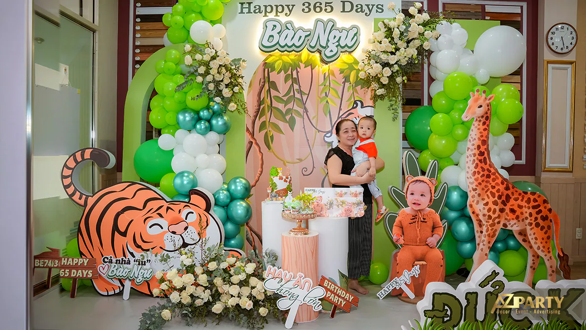 Gia đình lưu giữ kỷ niệm ngày thôi nôi bé Đức Khang trước phông nền thiết kế sinh động