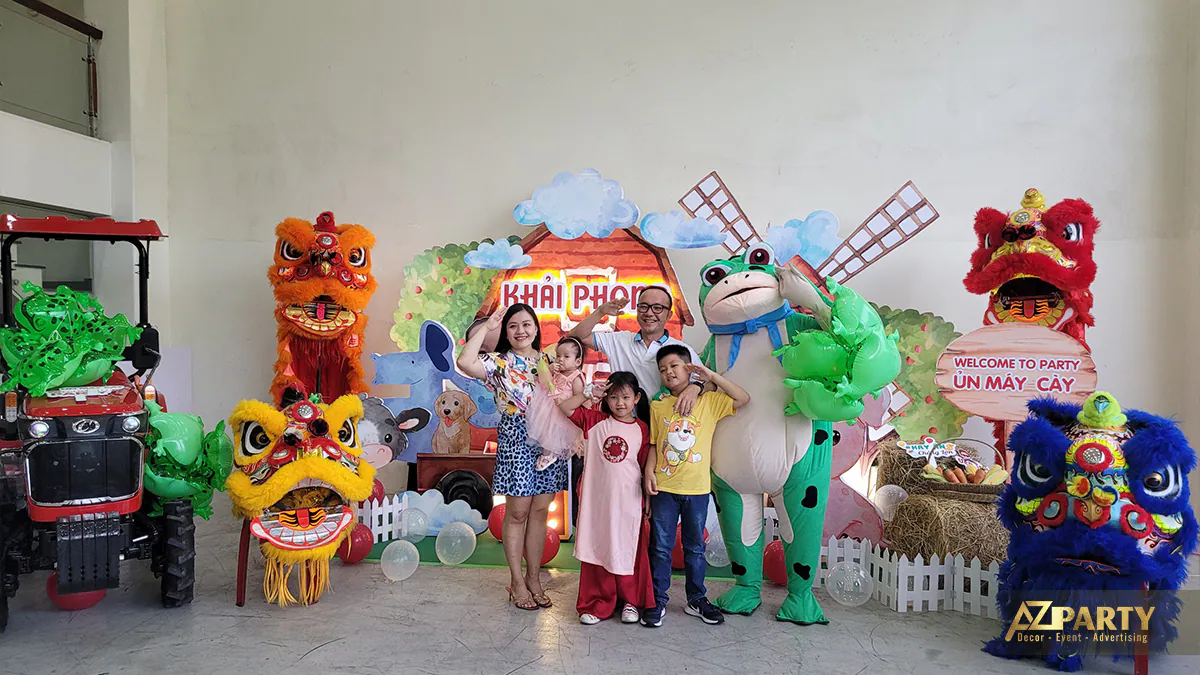 Gia đình bé Khải Phong chụp ảnh kỷ niệm vui vẻ cùng mascot ếch xanh và đội múa lân sư rồng náo nhiệt