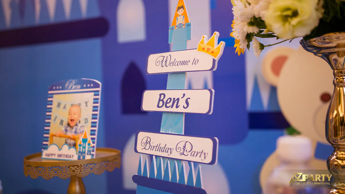 Mô hình lâu đài giấy độc đáo ghi dòng chữ Welcome to Ben's Birthday Party tại khu vực bàn tiệc thôi nôi bé Thái Thịnh