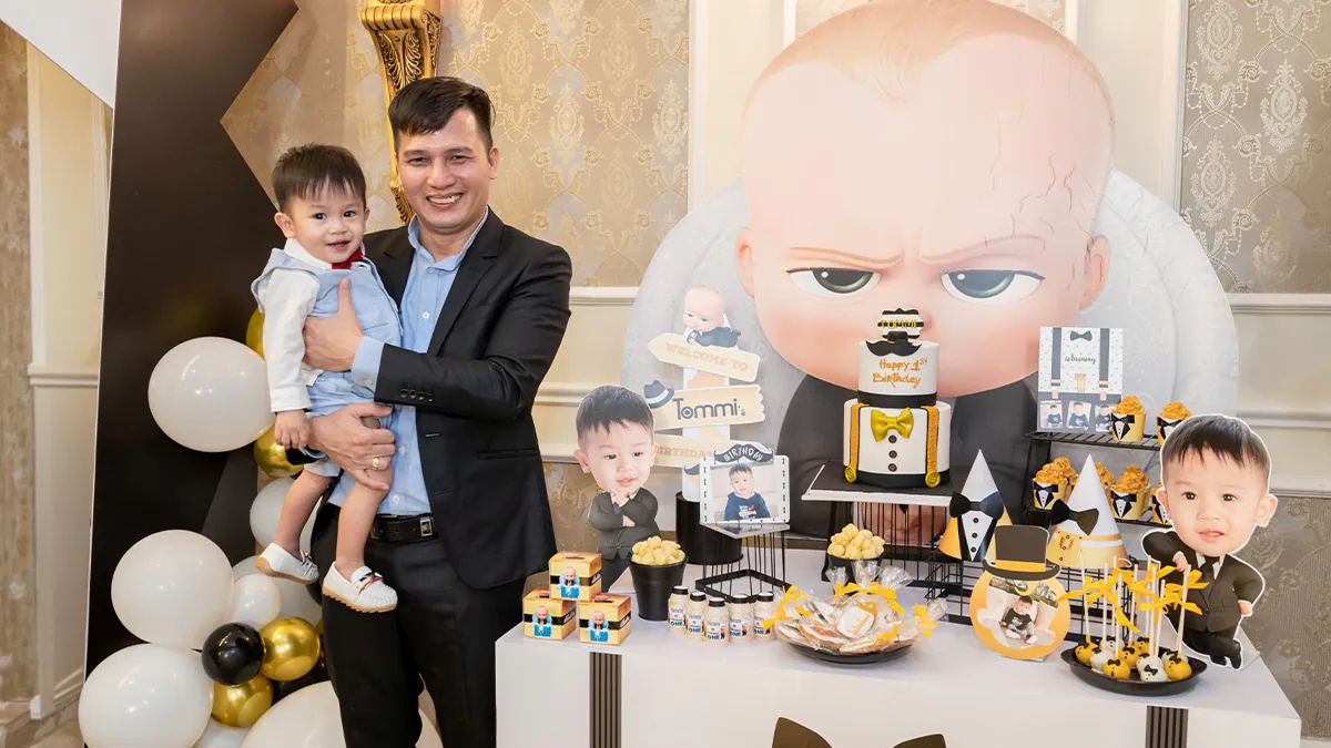 Hai cha con chụp ảnh bên bàn gallery thôi nôi được trang trí lộng lẫy