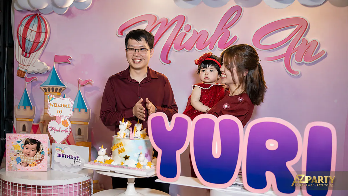 Gia đình hạnh phúc chụp ảnh lưu niệm bên cạnh chiếc bánh kem unicorn sắc màu