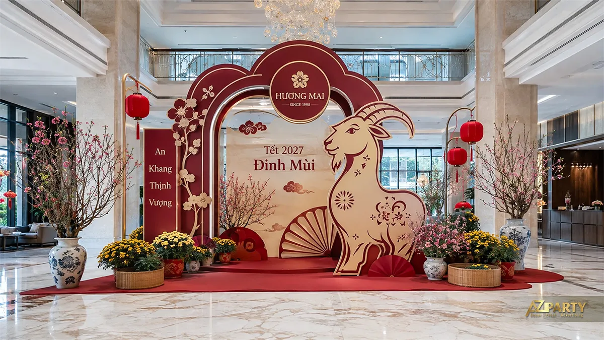 Mẫu trang trí sảnh công ty Hương Mai với cổng vòm đỏ kem, linh vật dê, hoa đào và cúc vàng