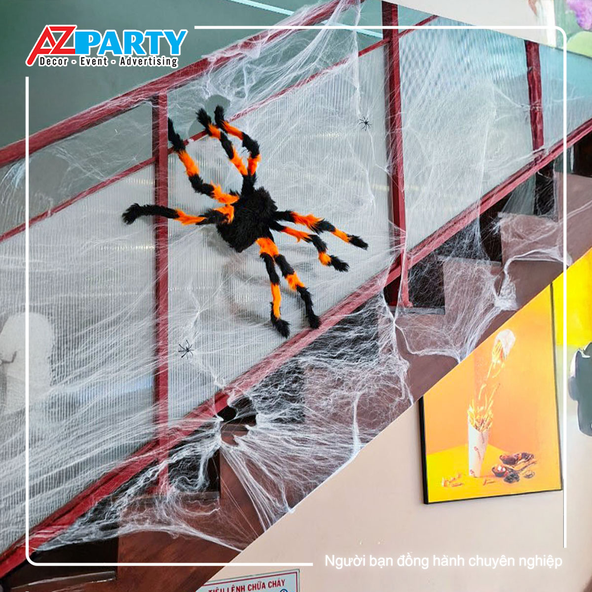 nhện màu vàng cam bám vào thang bộ cùng những tơ nhện