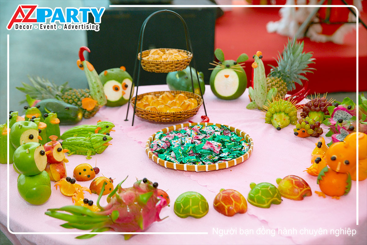 bàn trái cây, gồm có kẹo, bánh và các con vật được trang trí bằng trái cây
