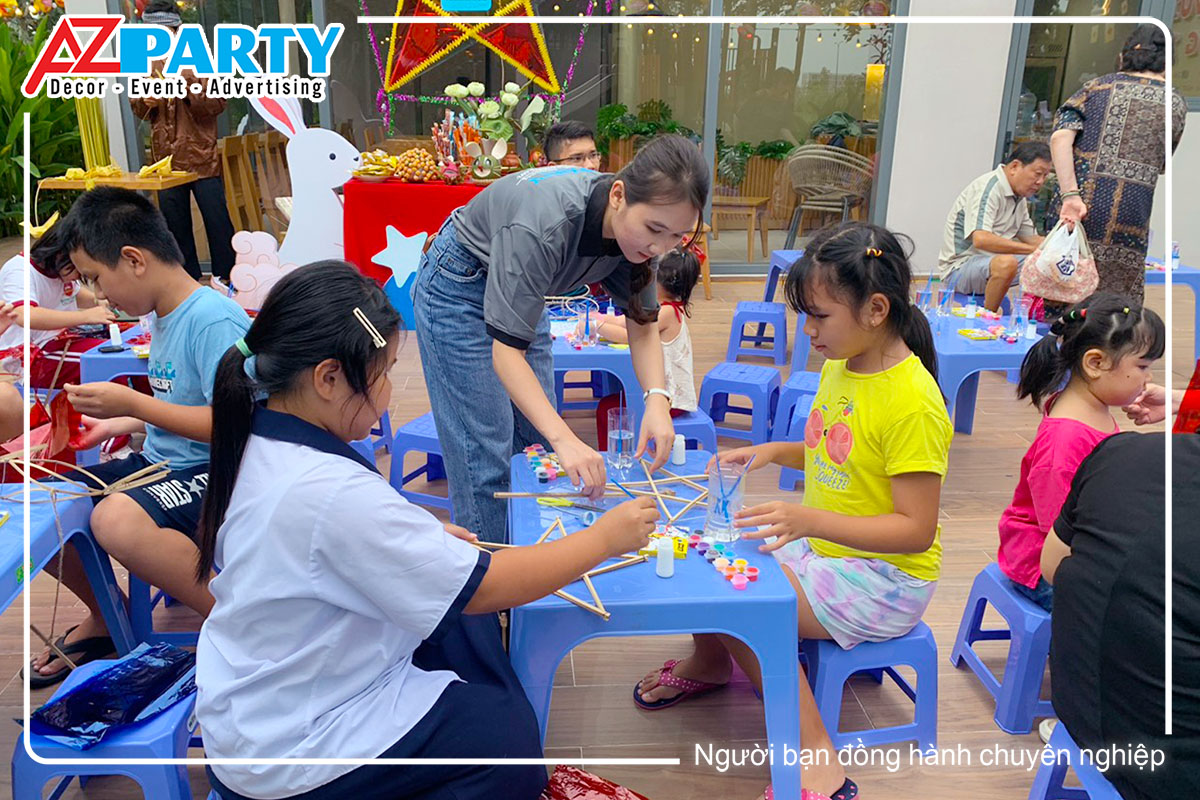nhân sự AZ hỗ trợ 2 bé gái làm lồng đèn trung thu