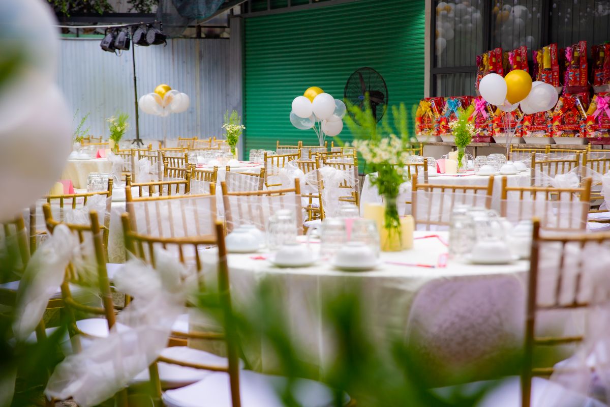 không gian bàn tiệc ngoài trời được set up chỉn chu với tone màu trắng, điểm xuyết với những nọ hoa trắng rực rỡ