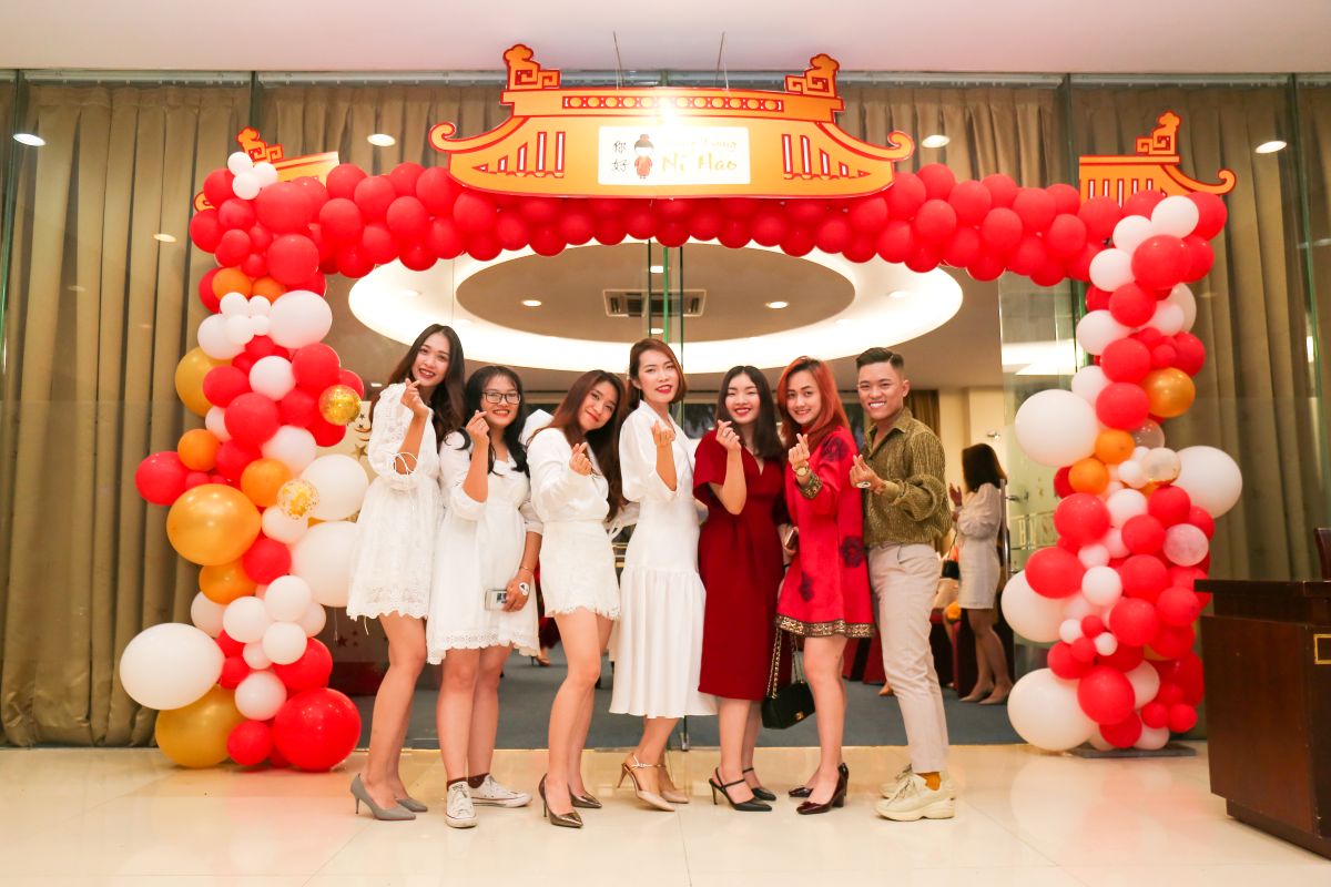 nhóm nhân viên chụp hình kỉ niệm tại cổng 