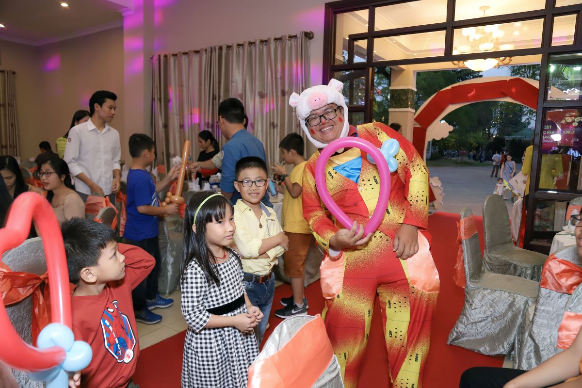 chú hề bong bóng trong buổi tiệc tất niên, mặc bộ trang phục cosplay chú heo