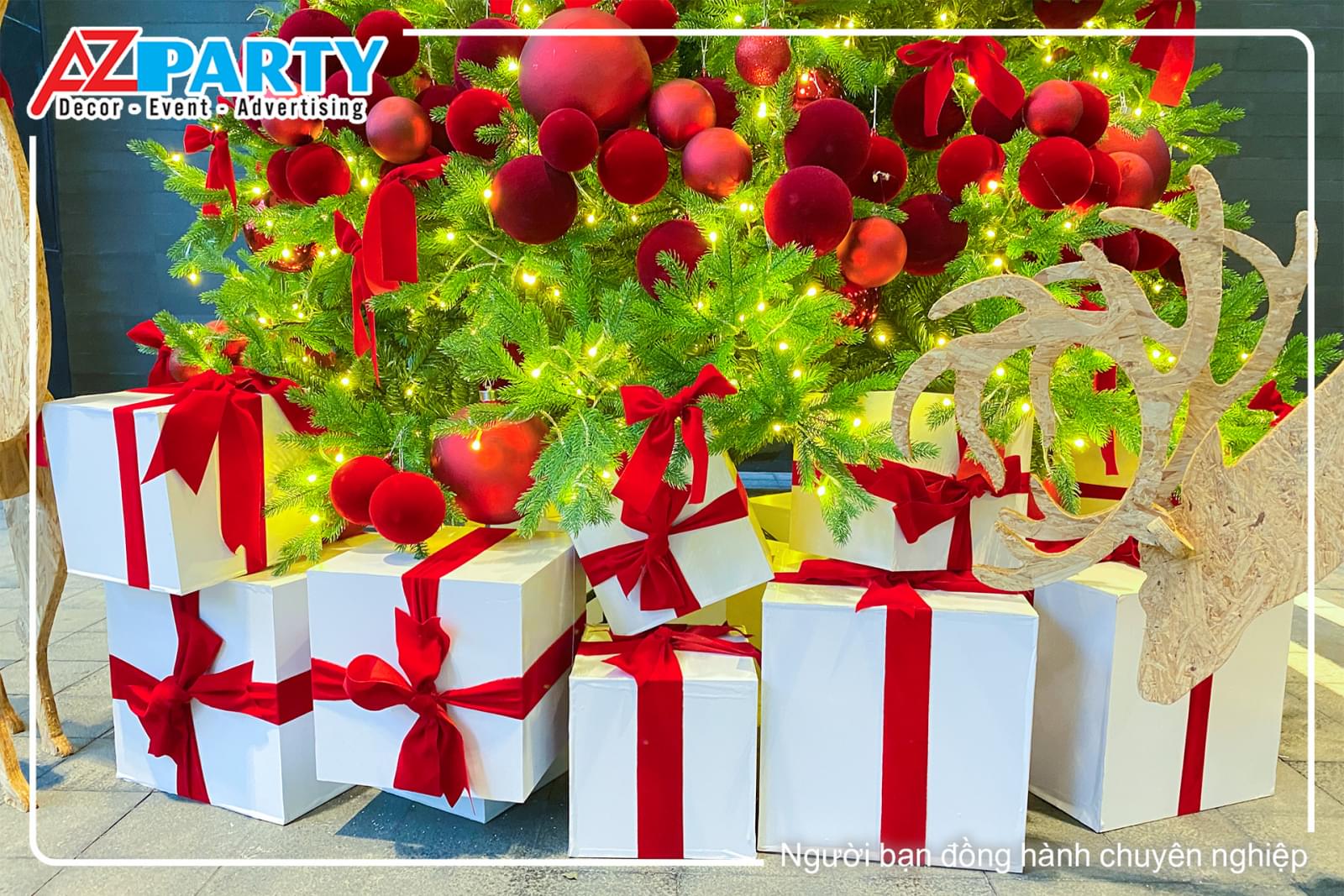 Các hộp qùa trắng nơ đỏ đặt dưới gốc cây thông