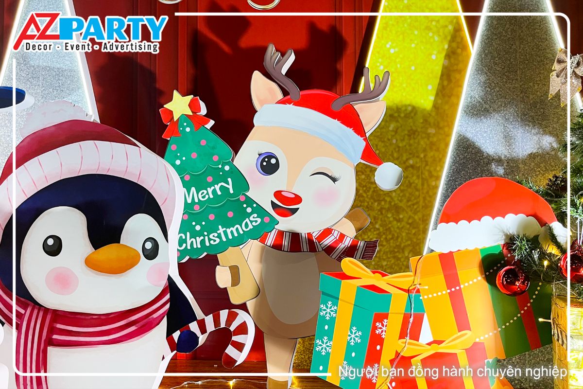 chú tuần lộc dễ thương cầm cây thông noel nhỏ, bên cạnh là chú chim cánh cụt 