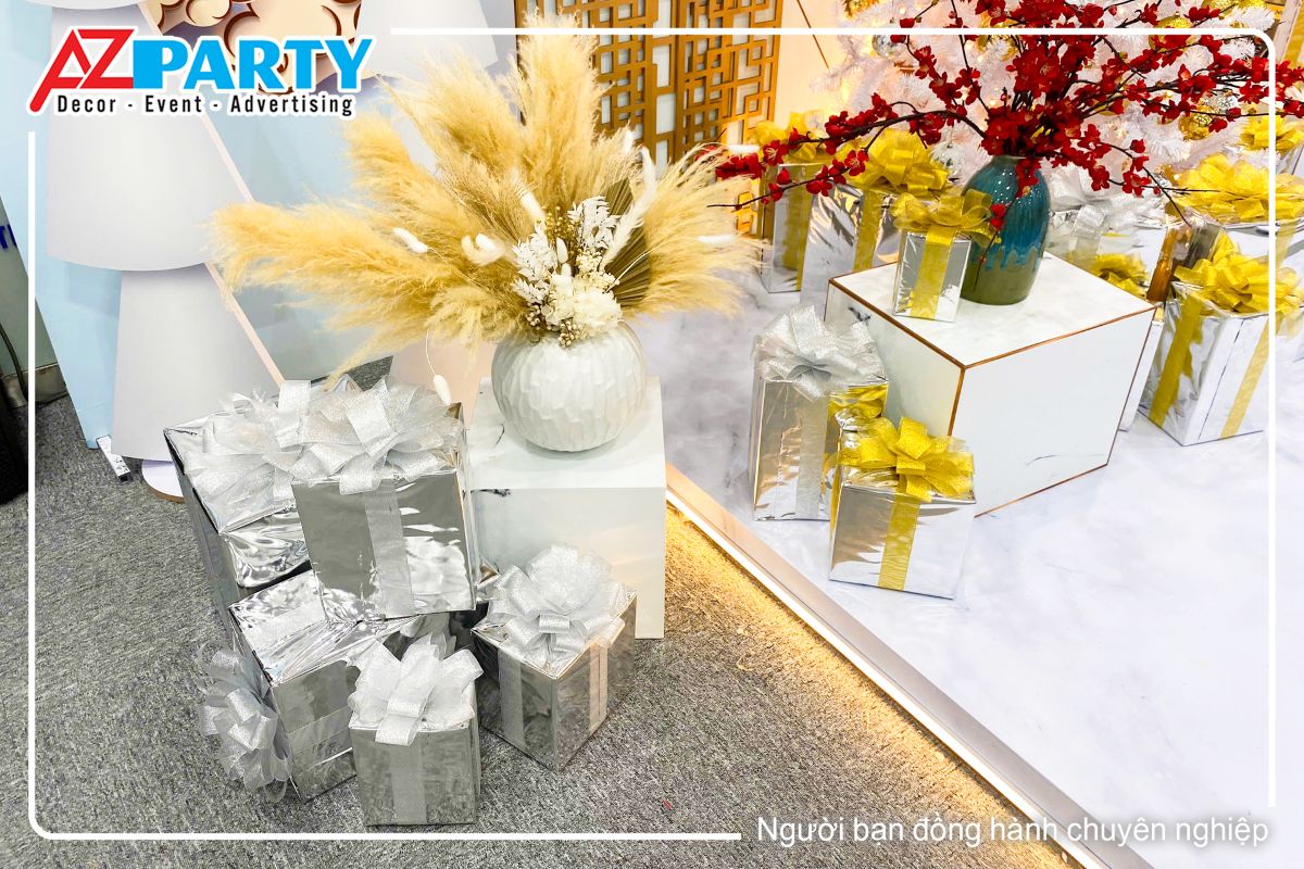 chậu cây bông lau vàng, dưới gốc cây là hộp quà màu trắng nhìn sang trọng