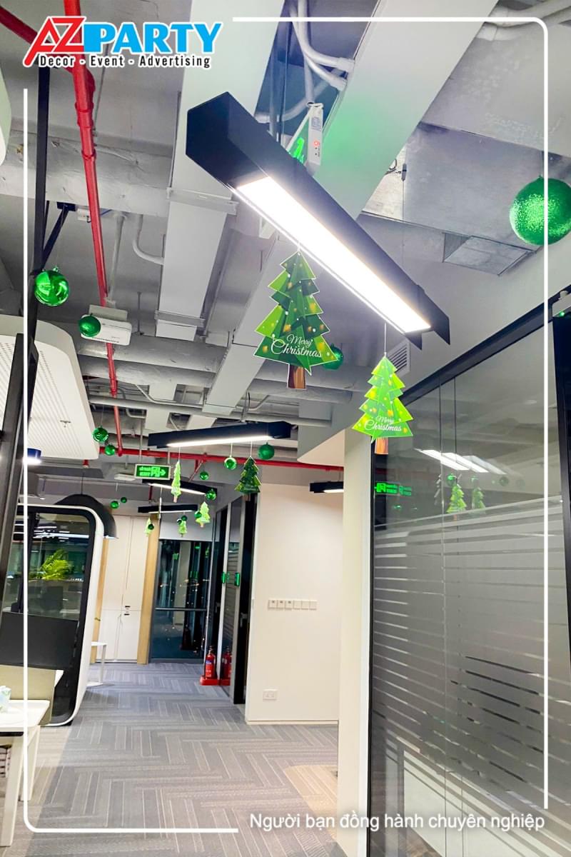 lối đi trong văn phòng có treo các quả châu xanh và cây thông noel mini