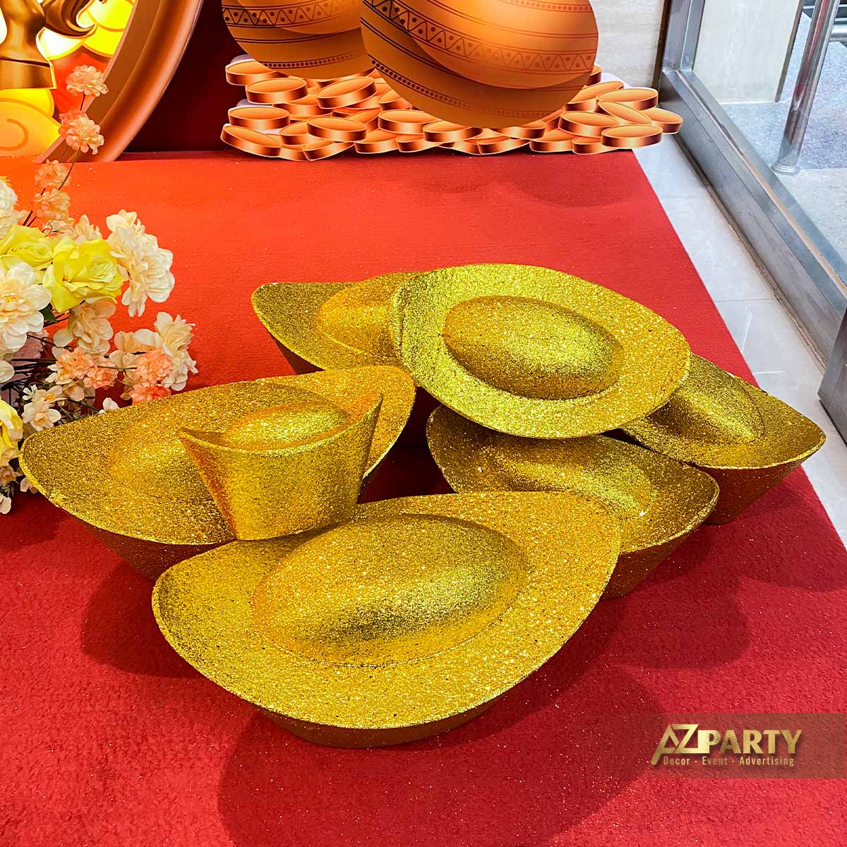 mô hình thỏi vàng kim tuyến trang trí trong tiểu cảnh Tết, biểu tượng tài lộc đặt trên thảm đỏ