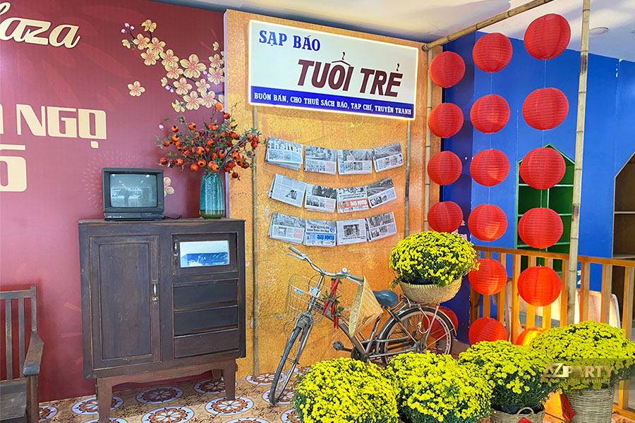 Góc tiểu cảnh Tết xưa với sạp báo Tuổi Trẻ, xe đạp cổ, đèn lồng đỏ và hoa cúc vàng