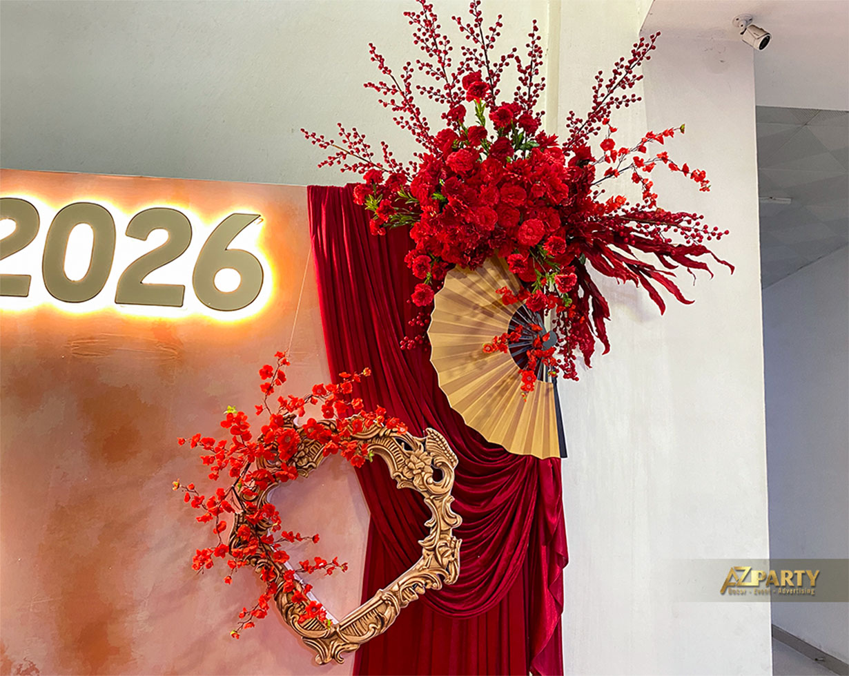 Chi tiết trang trí Tết 2026 với hoa đỏ, quạt giấy, khung trang trí cổ điển và rèm vải đỏ sang trọng