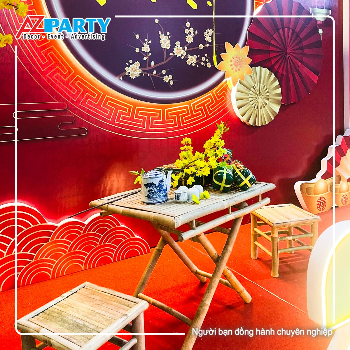 bộ bàn ghế tre, trên bàn có bộ ấm chén cùng cành mai vàng, bánh trưng, bánh tét