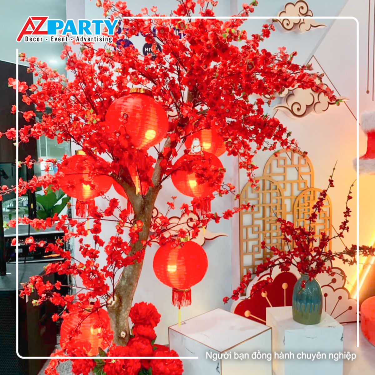 Cây hoa đào đỏ, trên cây có treo lồng đèn, bên cạnh cây hoa đào là chậu hoa đào để bàn