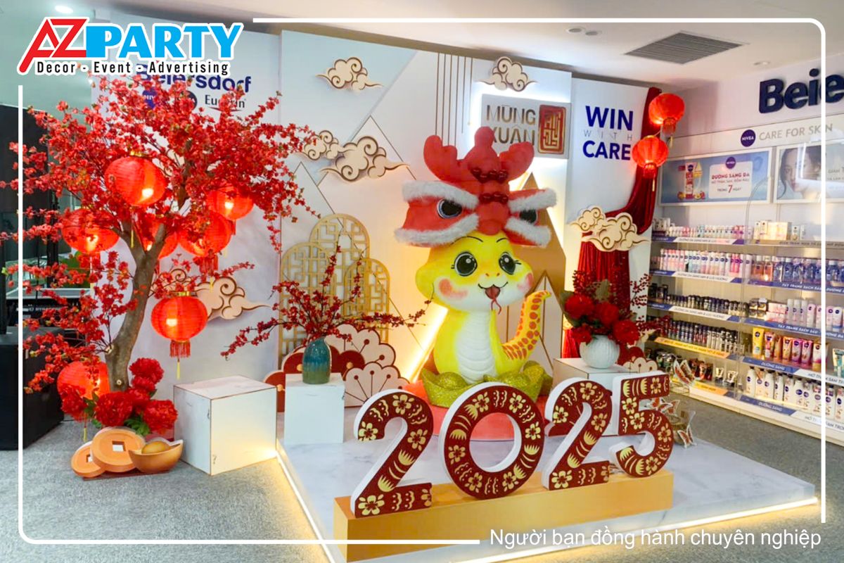 tiểu cảnh tết tại công ty Beiersdorf, nổi bật với 2 tone màu đỏ và trắng. Ở giữa là mô hình chú rắn vàng dễ thương cùng bộ chữ 2025 rực rỡ.